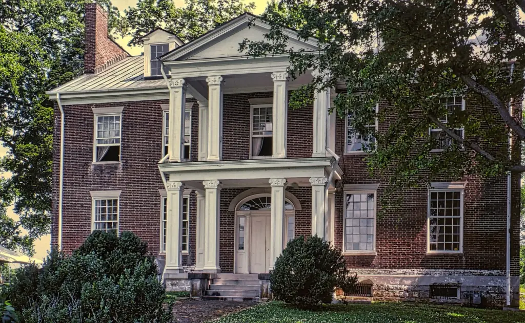 The brick front of Carnton, a two-story plantation house with a columned double porch, framed by trees