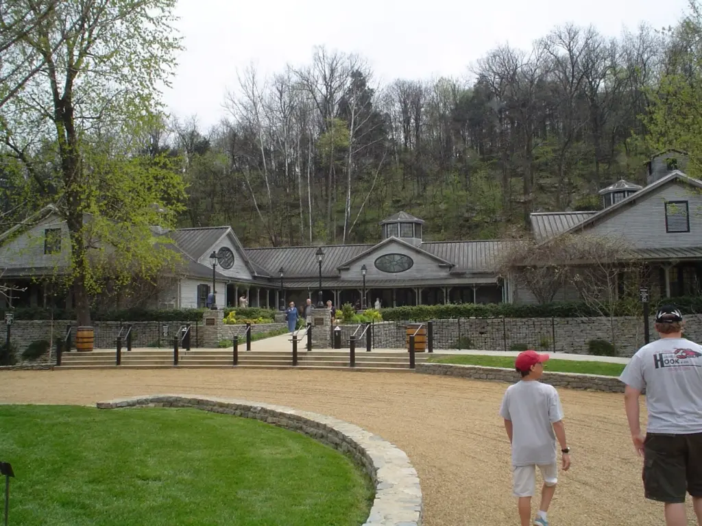 The low gray visitor center of the Jack Daniel Distillery in Lynchburg with a circular drive and trees behind