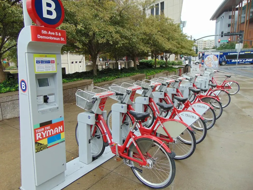 A row of red BCycle bikes docked at a bike-share station in downtown Nashville