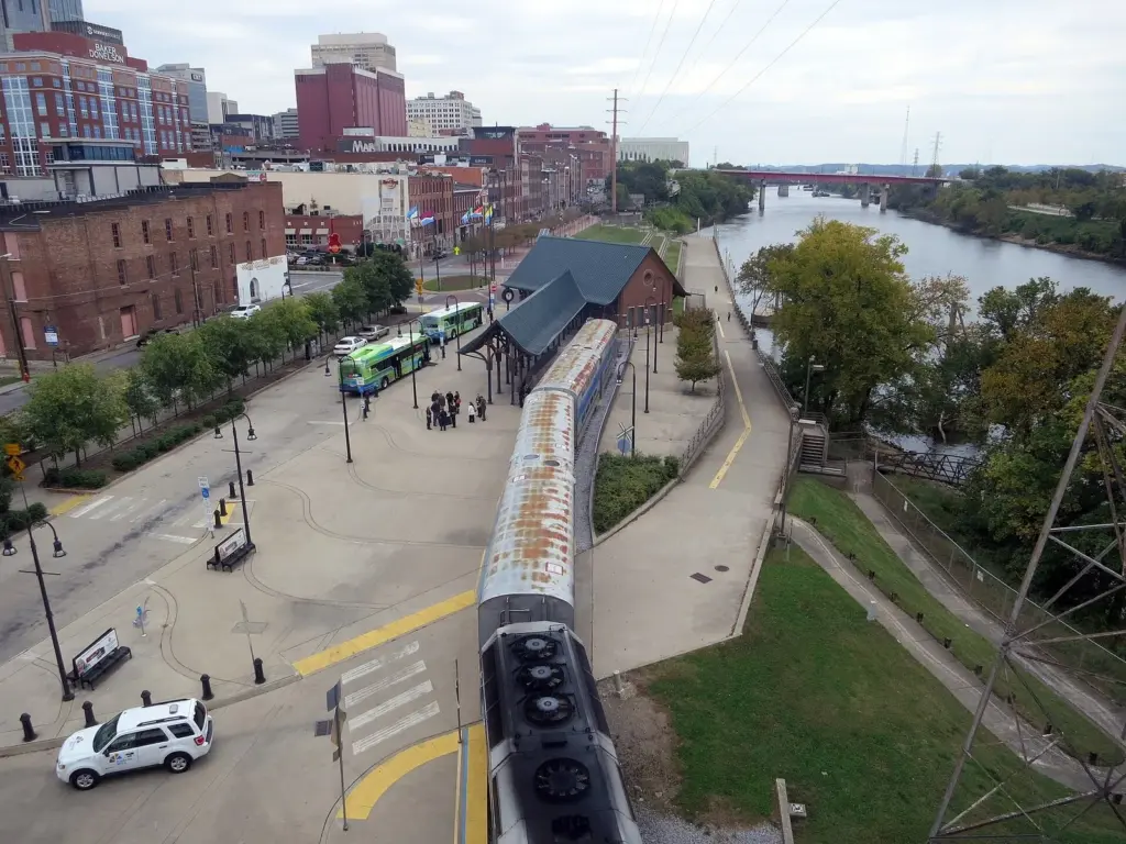 A commuter train with a locomotive and double-deck cars at Riverfront Station beside the Cumberland River