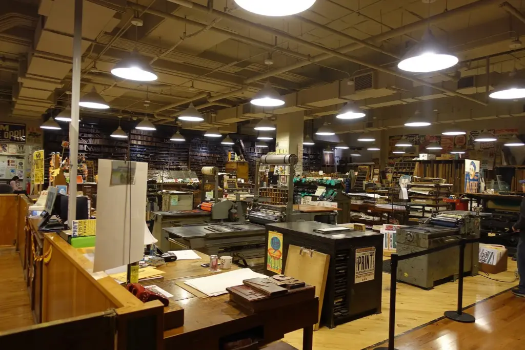 The interior of Hatch Show Print with old letterpress machines, type cabinets and hanging posters