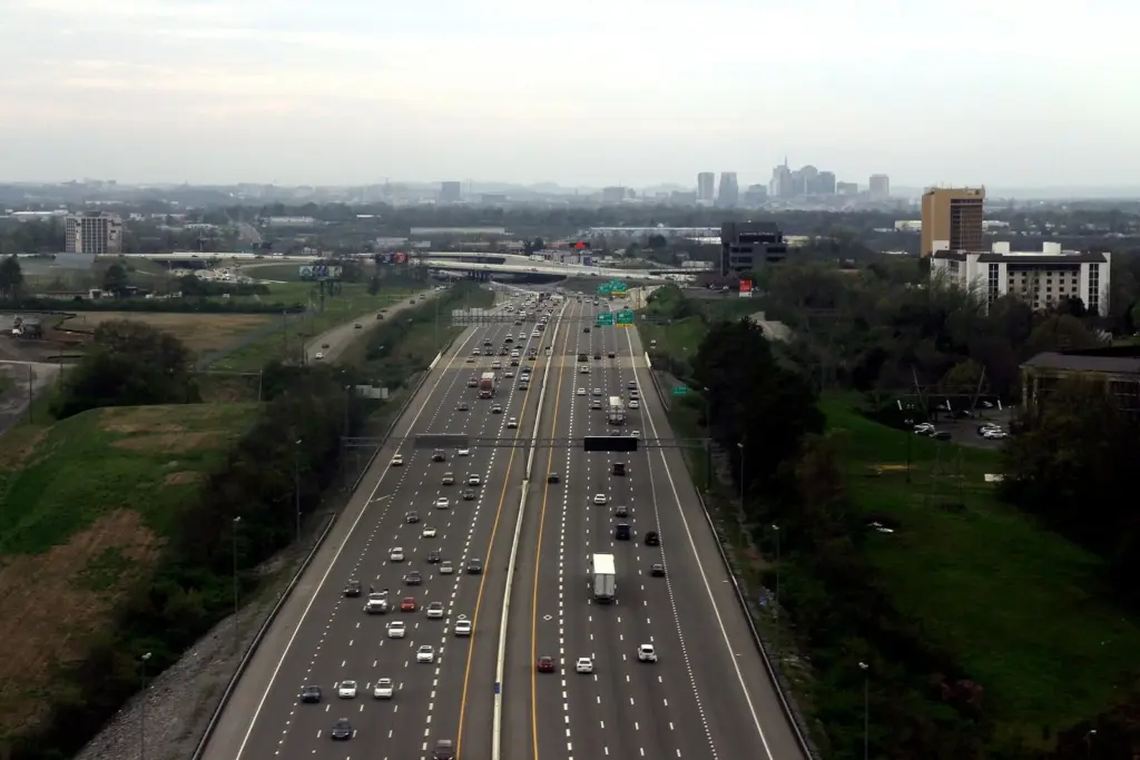 Traffic on Interstate 40 near the airport with the skyline in the distance, a reminder that getting around Nashville by car means planning for rush hour