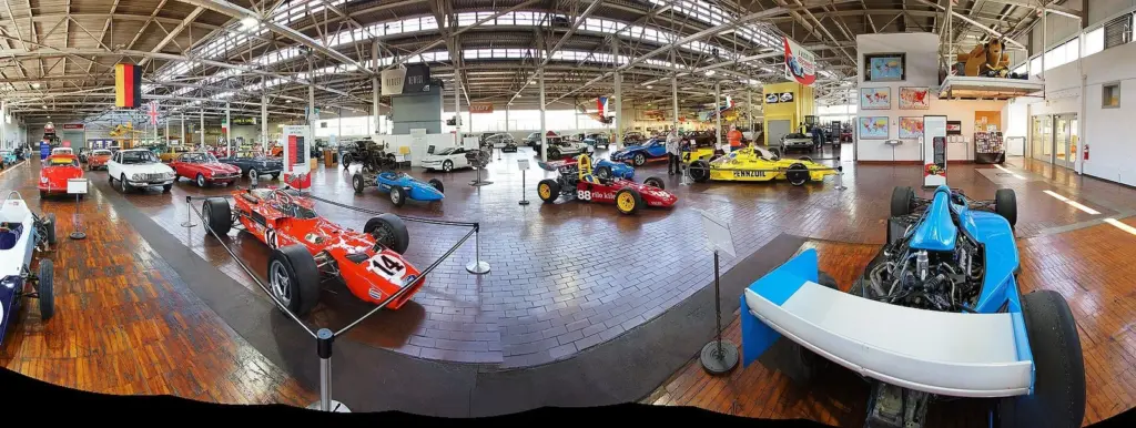 A panoramic view of the Lane Motor Museum hall filled with race cars and unusual vehicles