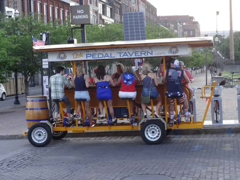 Riders pedaling a Nashville Pedal Tavern bike along a downtown street
