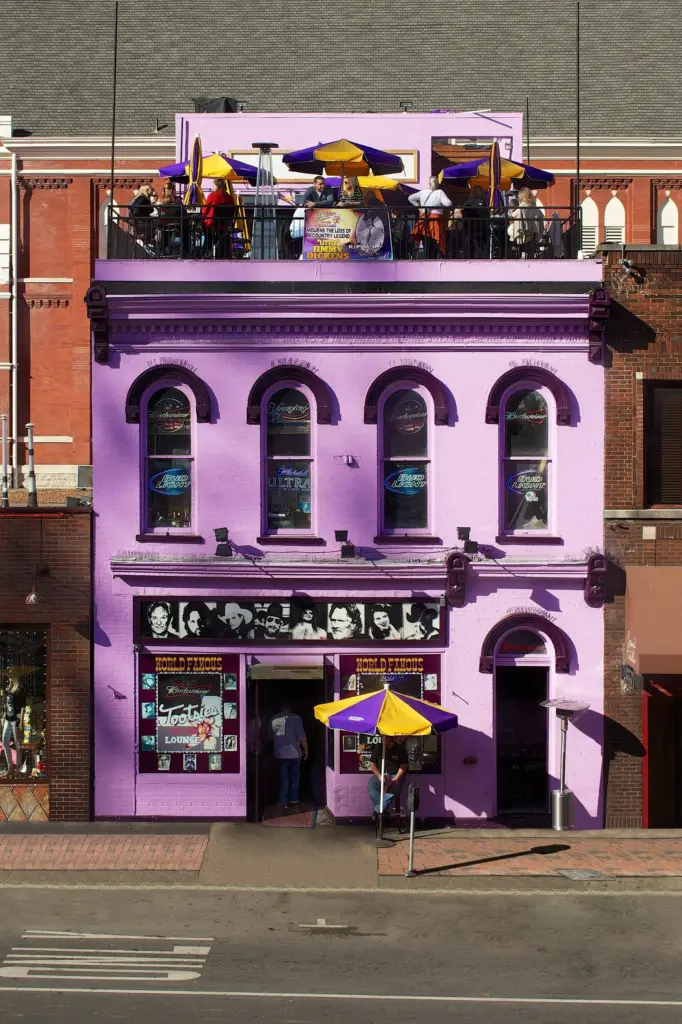 The purple facade of Tootsie's Orchid Lounge with umbrellas on its rooftop deck
