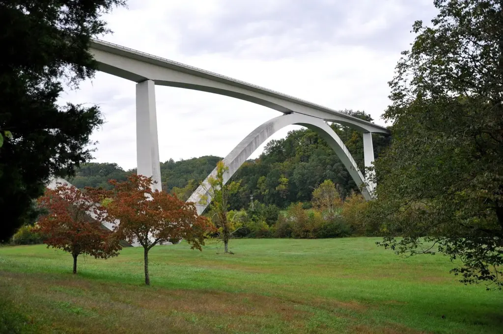 The white concrete Double Arch Bridge carrying the Natchez Trace Parkway over a green valley