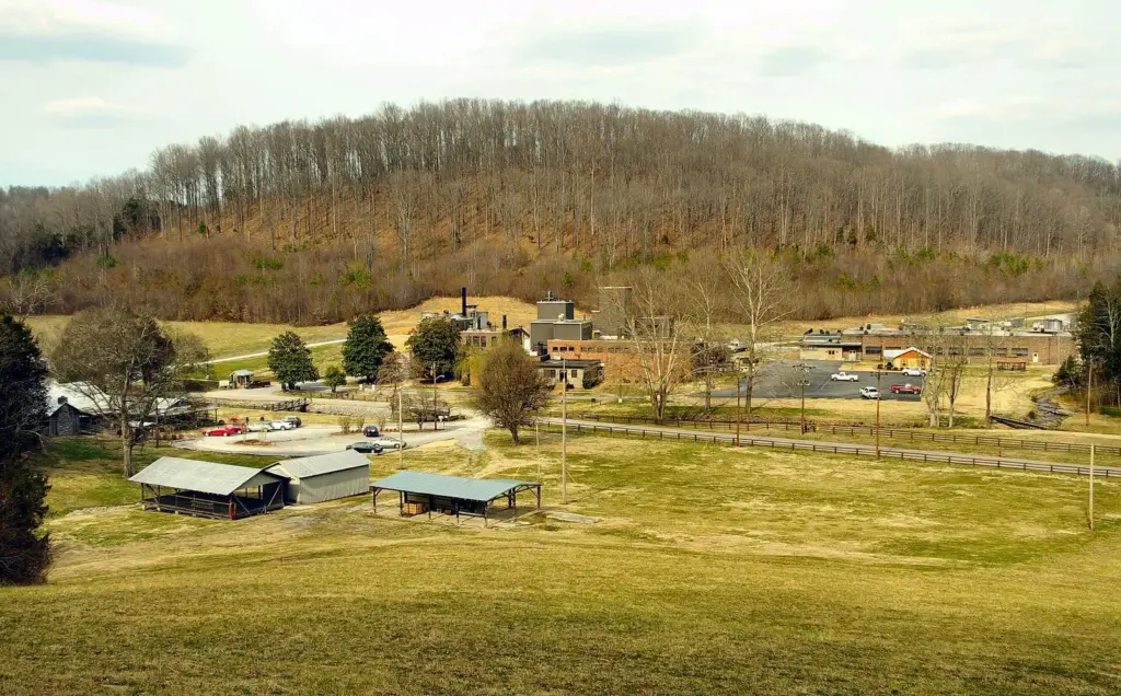Distillery buildings and parking lots spread across the floor of a wooded hollow at Cascade Hollow, home of George Dickel, in early spring