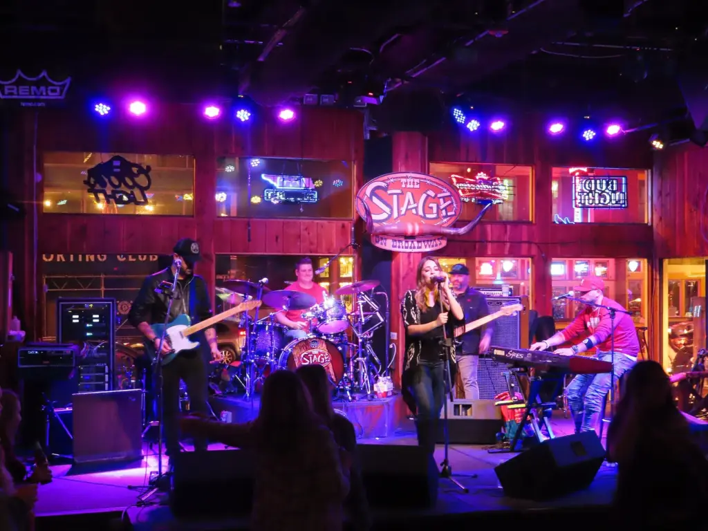 A band playing under purple stage lights inside The Stage on Broadway