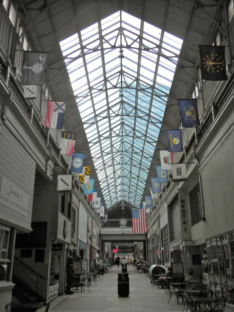 The glass-roofed Arcade, a historic corner of shopping in Nashville, with flags hanging above two levels of shops